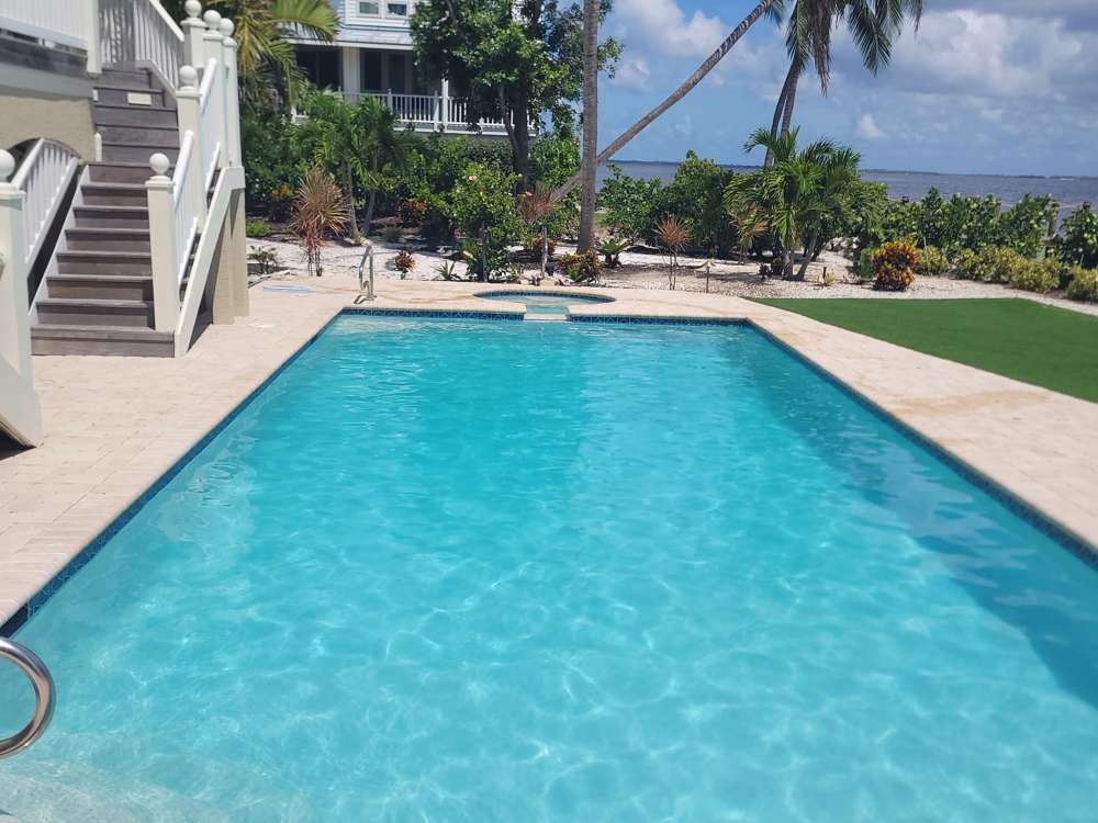 Bayfront pool with travertine deck, steps and open-water views
