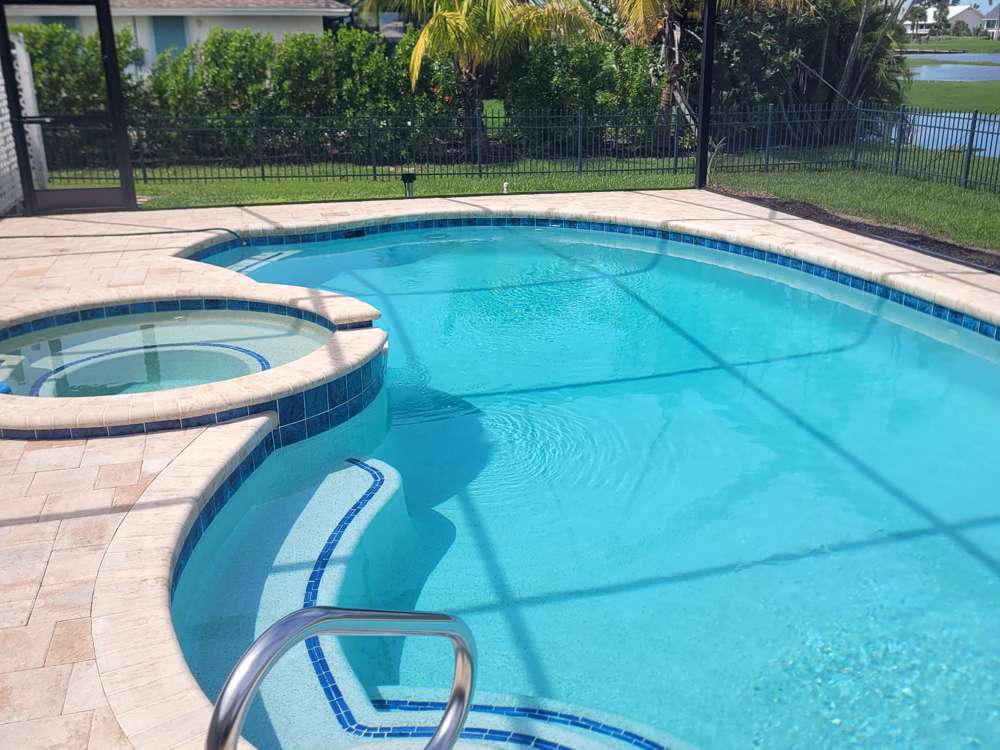 Freeform pool and spa under a screened lanai