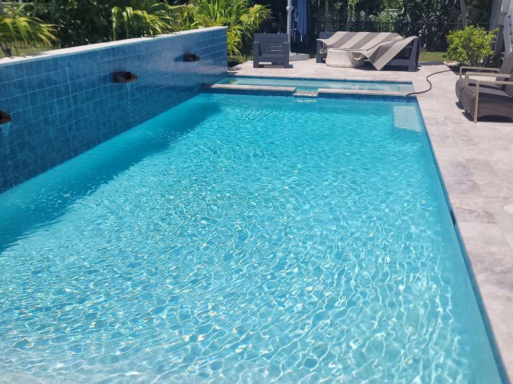Rectangular pool with loungers and tropical landscaping